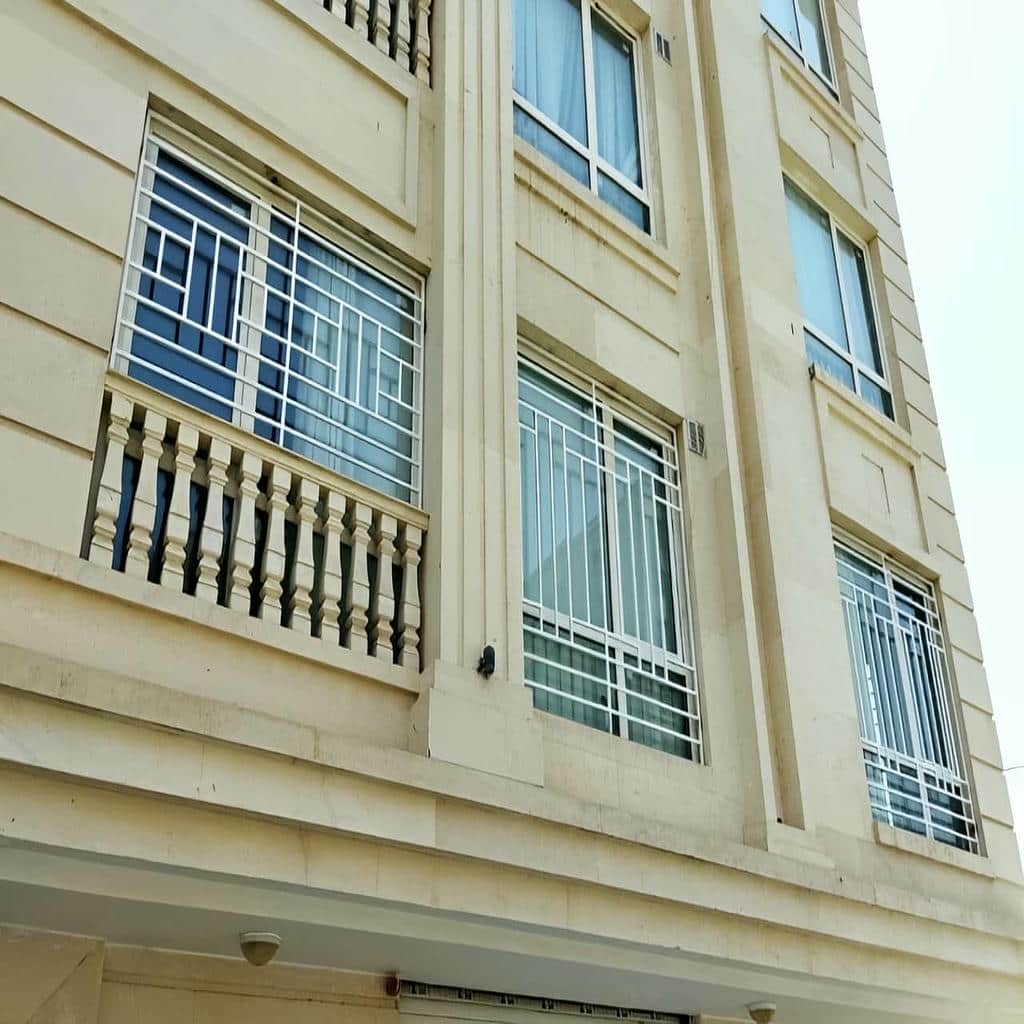 حفاظ پنجره سفید روی نمای آجری روشن حفاظ پنجره سفید روی نمای آجری روشن