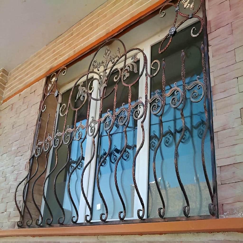 محافظ پنجره آهنی کنار نمای سنگی خانه