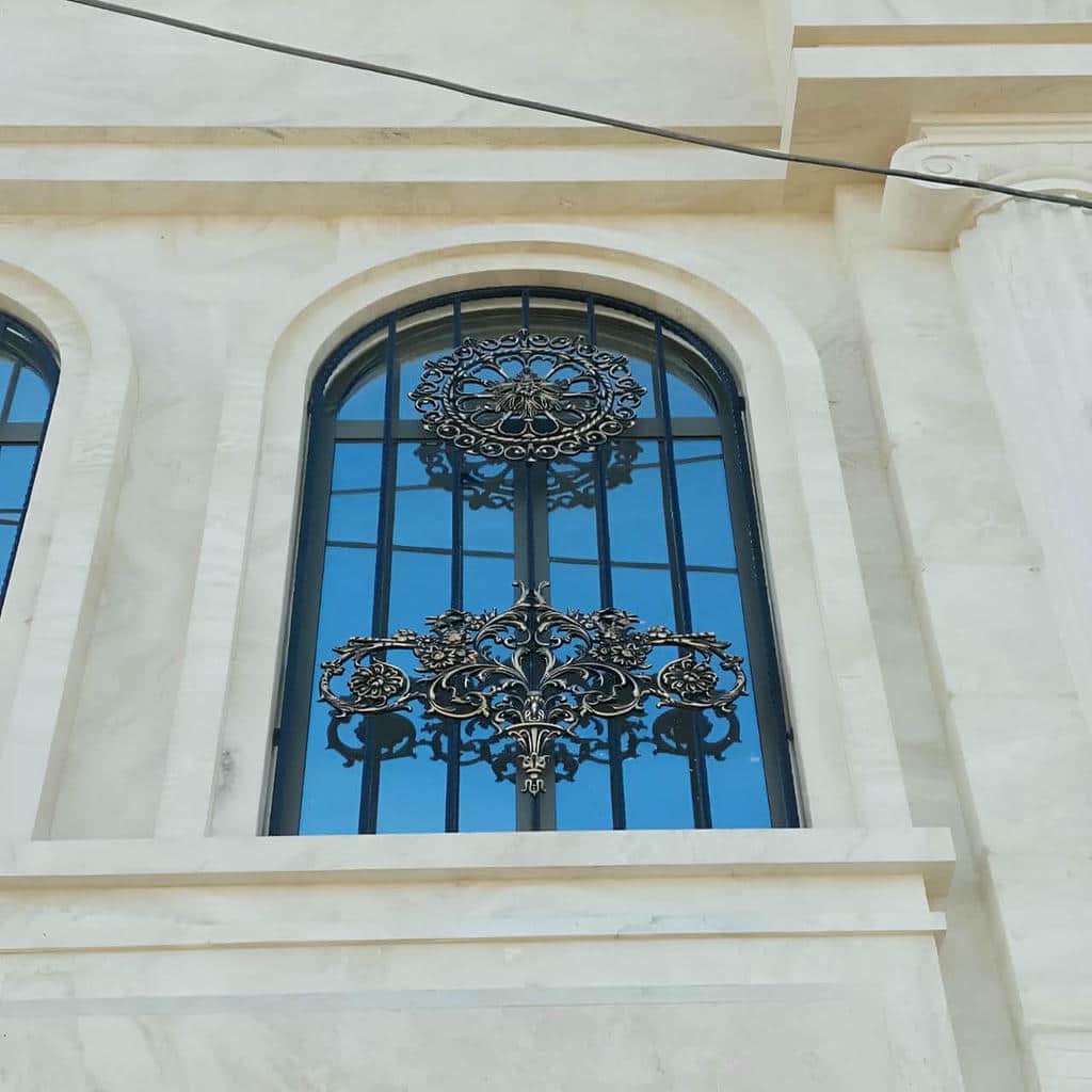 نرده پنجره سفید با خطوط ساده روی نمای آجری