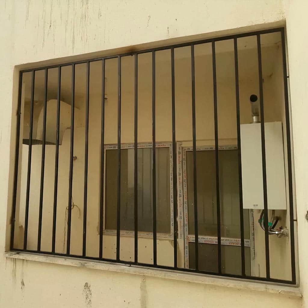 گارد پنجره سفید روی نمای سنگی باغ